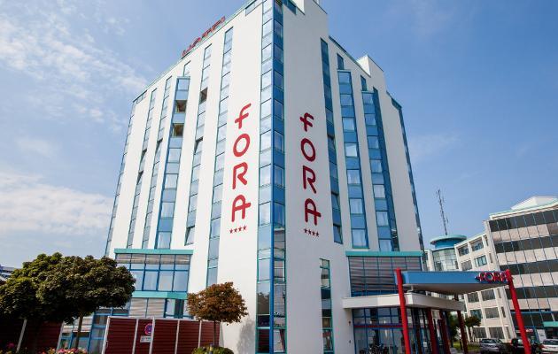 Blick auf das Hotel FORA Hannover by Mercure: Modernes Gebäude vor blauem Himmel